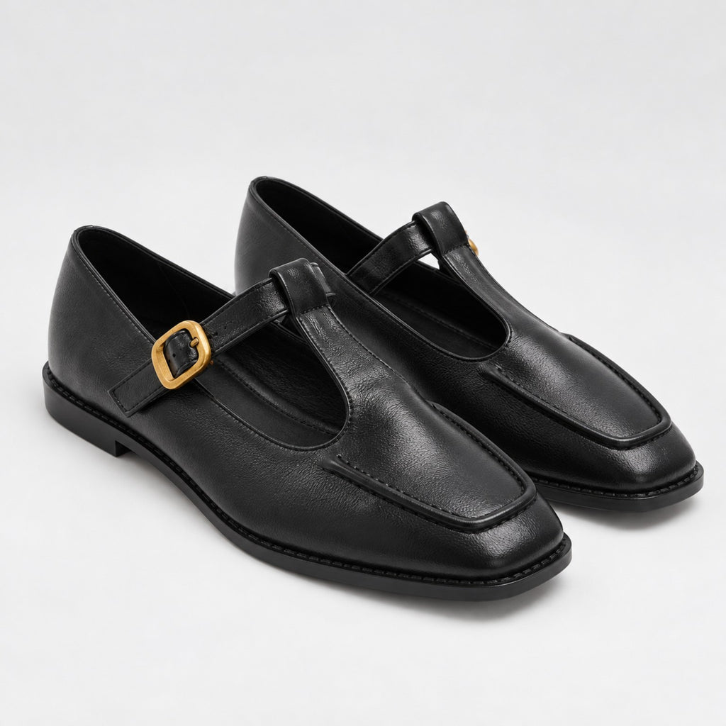 Par de sapatos pretos com fivela dourada